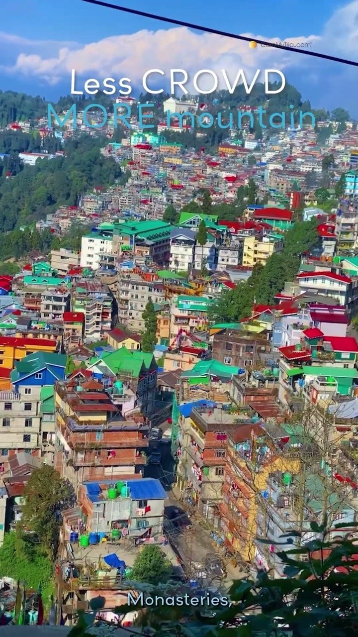 A hillside town of colourful houses in Darjeeling, captioned Less crowd, more mountain